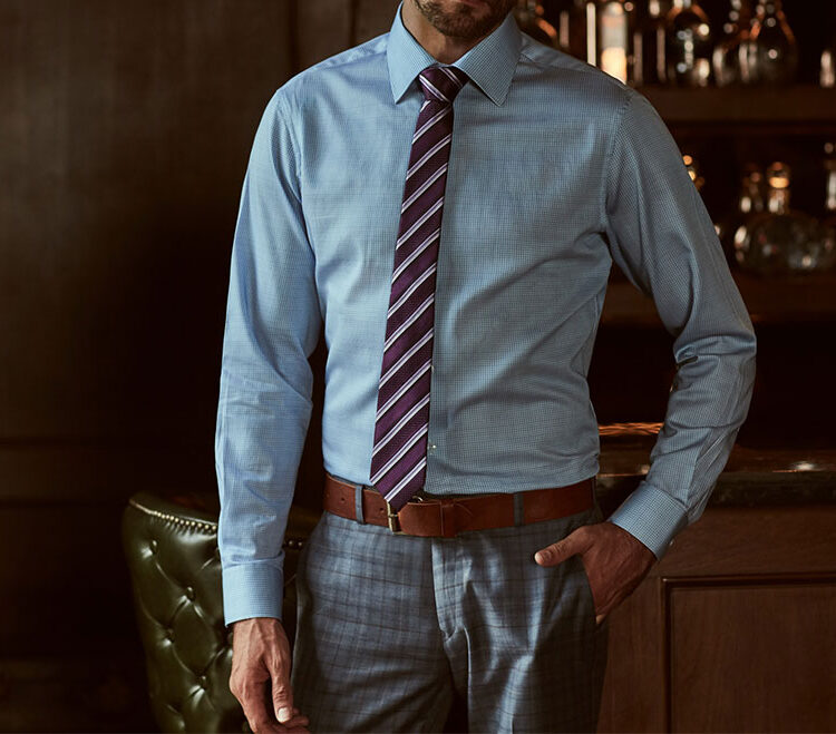 A man posing in a formal attire in a dark aesthetic for Tailoring