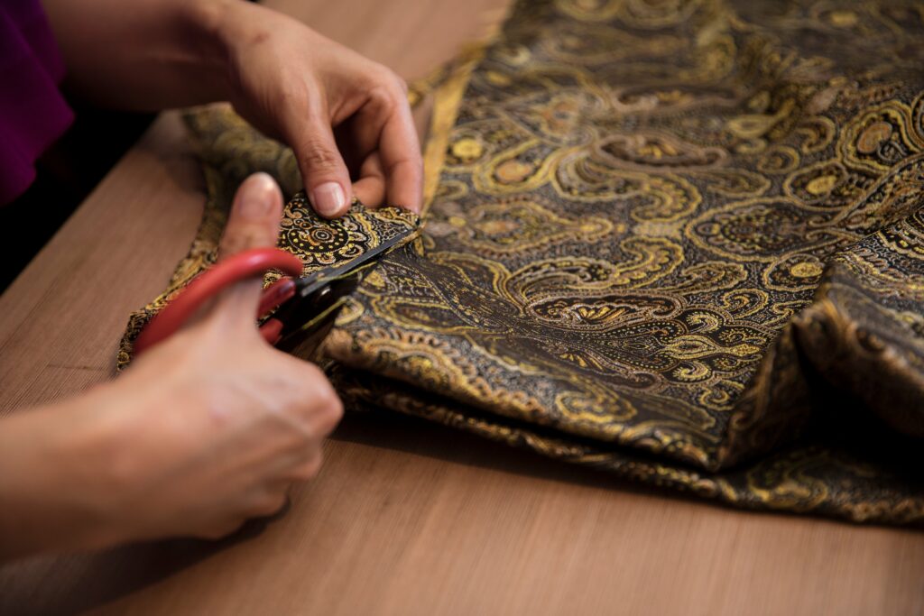 tradition to modern tailor cutting silk fabric with scissors